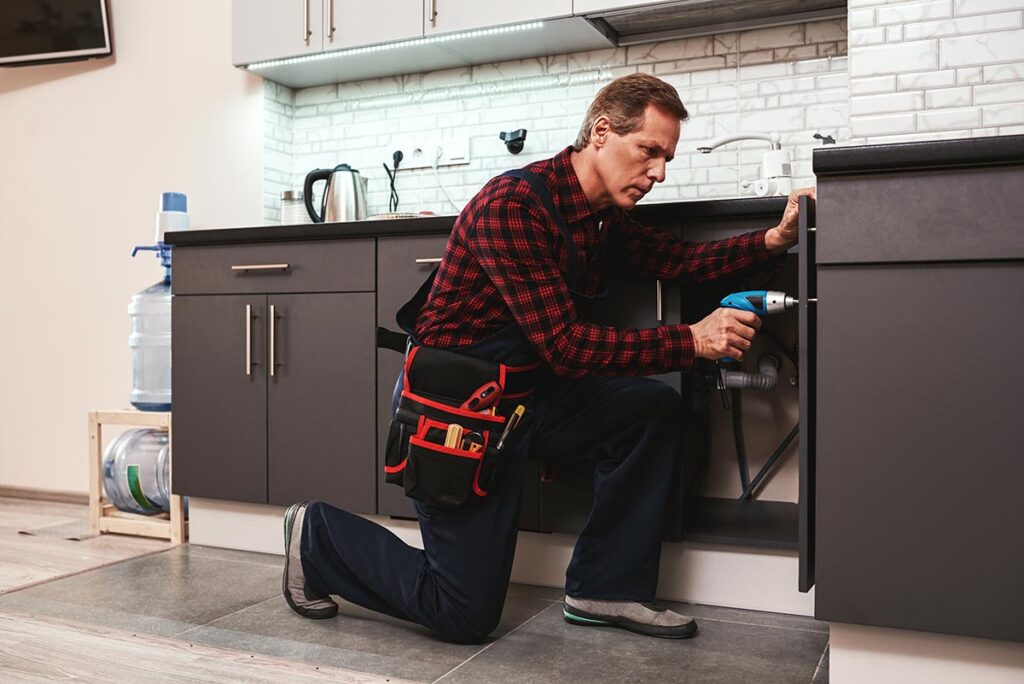 handyman repairing cabinet doors