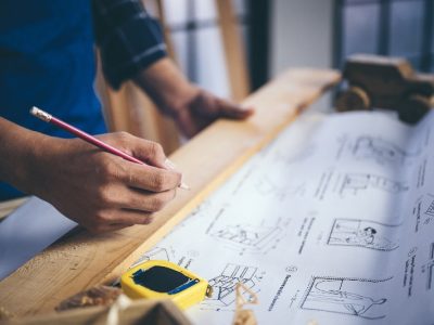 A carpenter working on a blueprint